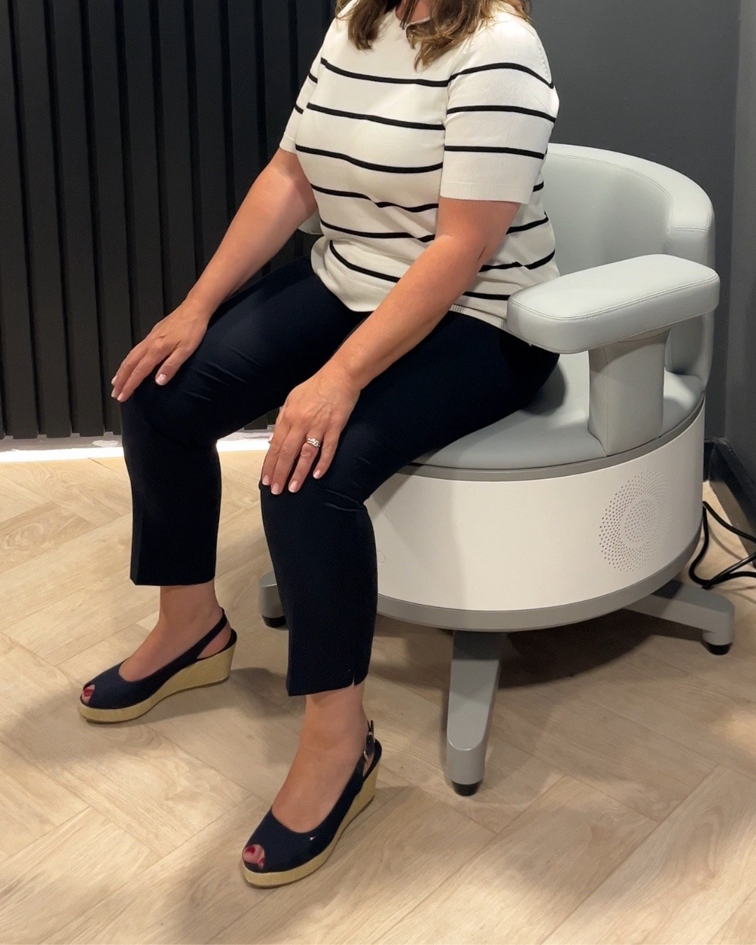 A fully clothed person seated on the Ultra Tesla Seat